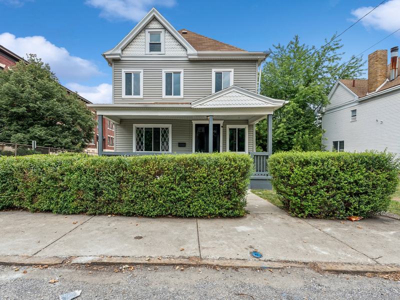 After renovation: renovated front with a new porch and trimmed hedges, house on 1128 McCleary St, McKeesport PA