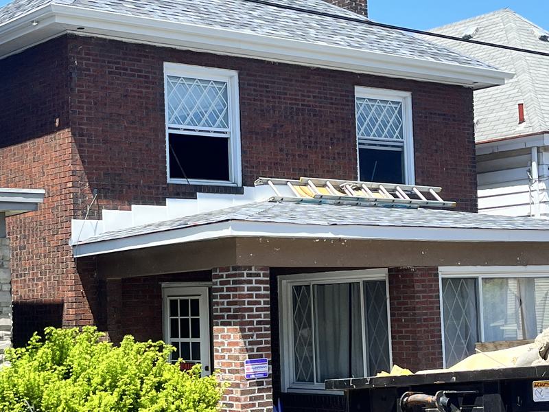 Before renovation: front of the brick house before work, with trash bins out front, house on 1316 Craig St, McKeesport PA