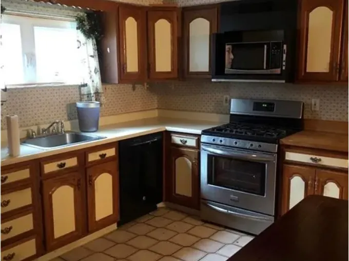 Before renovation: dated kitchen with brown cabinets and tile floor
