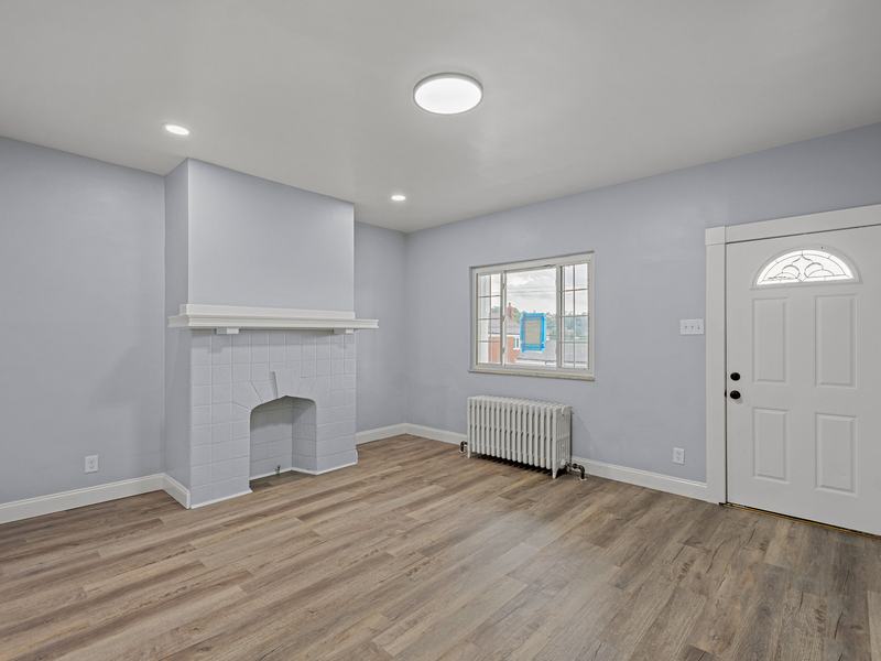 After renovation: living room with new flooring, fresh paint and a restored fireplace, house on 1821 Westmont Ave, Pittsburgh PA