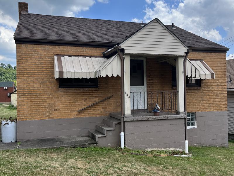 Before renovation: front of the house with old striped awnings, house on 444 27th St, McKeesport PA