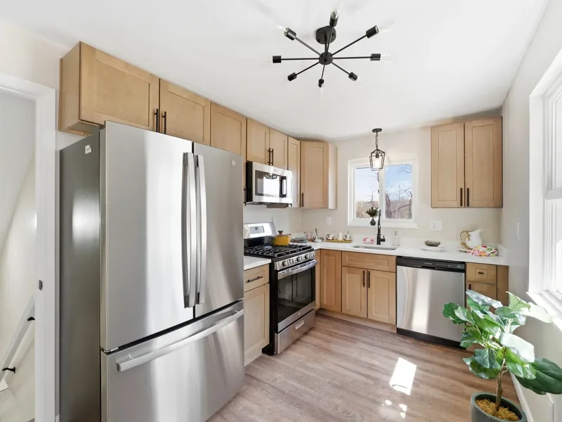 After renovation: kitchen with wood cabinets and stainless steel appliances