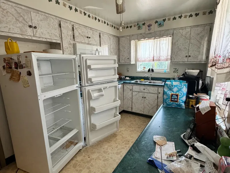 Before renovation: dated kitchen with dark counters and clutter