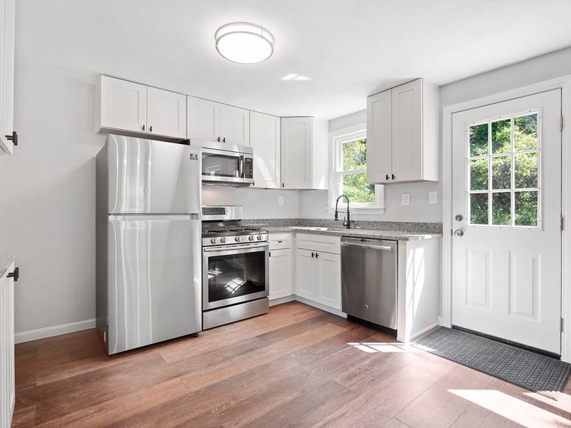 After renovation: kitchen with white cabinets, stainless steel appliances and new flooring, house on 625 Irwin Run Rd, West Mifflin PA