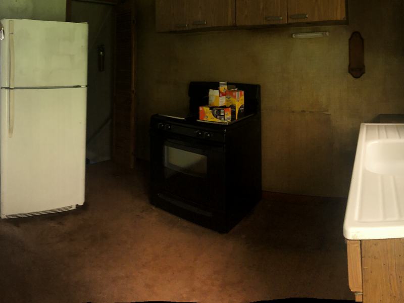 Before renovation: dated kitchen with an old sink, a white refrigerator and dark walls, house on 625 Irwin Run Rd, West Mifflin PA