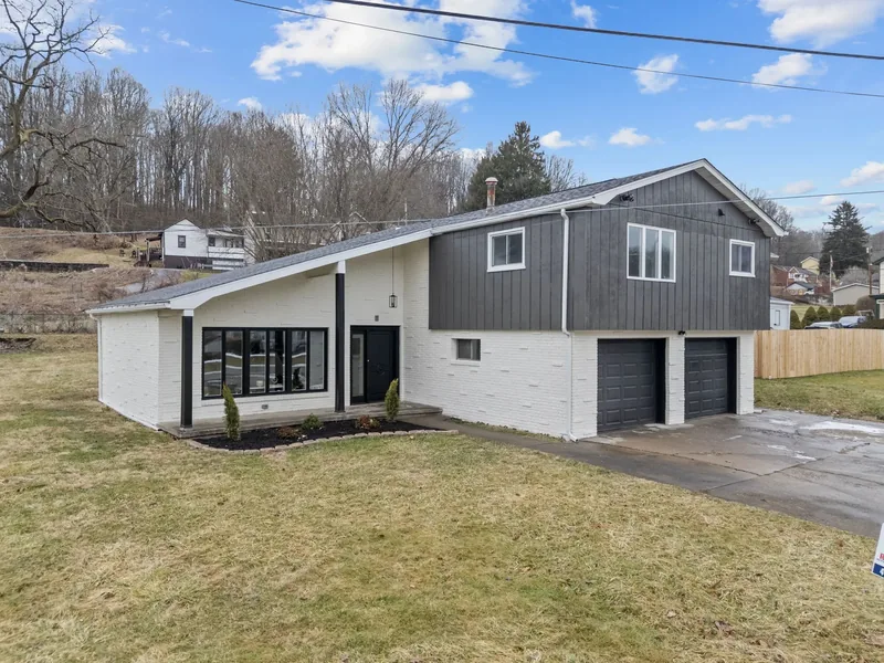 After renovation: house with modern gray and white siding and a two car garage