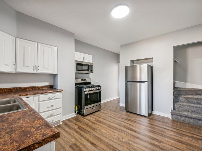 After renovation: kitchen with white cabinets, new flooring and stainless steel appliances, house on 815 Monongahela Ave, Glassport PA